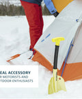 Grab And Go Collapsible Snow Shovel For Camping And Car Emergency Kit next to a tent in the snow