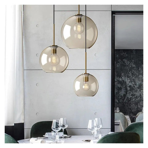 Nordic Industrial Glass Pendant Light Modern Single Lamp for Dining Bar Creative Decor,Artistic, three glass globes hanging above a dining table.