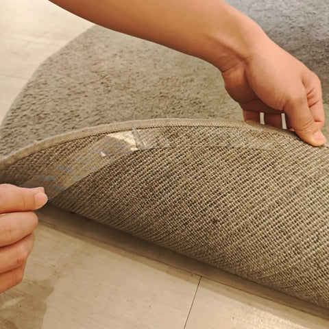 Hands placing Eight Pack Rug Gripper Pads For Round Rugs 4x4 To 6x6 Feet With Curved Edge Design on underside of a round rug.