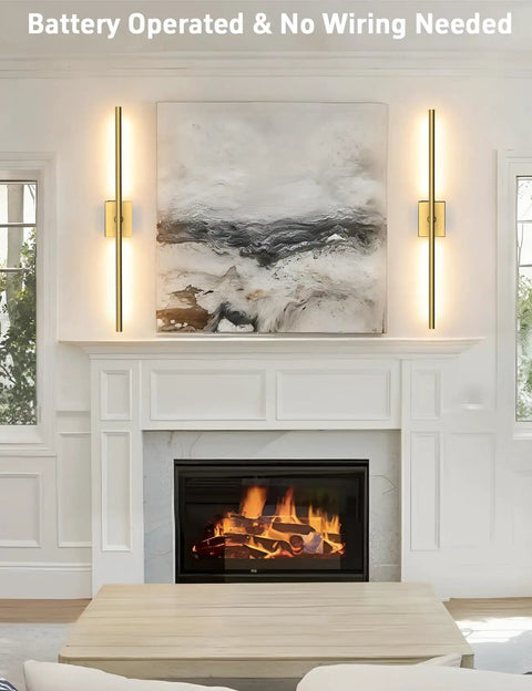 Slick Wireless Rechargeable Wall Sconces Set Of 2 Battery Powered Gold Light Fixtures mounted beside artwork in living room.