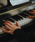 Hands playing piano keys with sheet music, showcasing Heavy Duty Long Folding Butt Hinges In Classic Antique Bronze Finish Pack Of Four Rock Solid Iron Hardware.