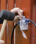 Person installing 50Ft Outdoor Power Extension Cord With Seven NEMA 5 15R Outlets 14 Gauge SJTW Cable on a wooden wall.