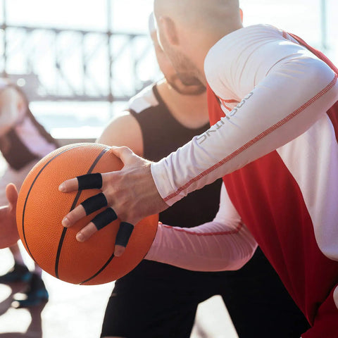 Basketball player wearing 12 Finger Sleeves For Arthritis With Breathable Elastic Fabric during a game, providing joint support and grip.