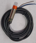PR12-4DP Inductive Proximity Sensor With PNP Output 4mm Sensing Range, metal body with orange cap, coiled cable attached.