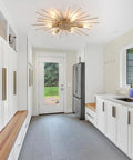 Gold Sputnik Ceiling Light Fixture 12 Light Firework Chandelier in a modern white kitchen setting with large window view.