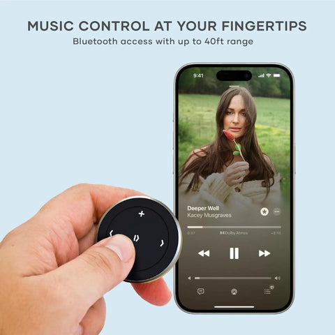 Person holding Bluetooth Media Button With Steering Wheel Mount For Cars And Bikes, Wireless Hands Free Play Pause, Skip Tracks, And Volume Control, Works With iPhone, iPad, Android, MacBook, And All Major Car And Bike Audio Systems, next to smartphone displaying music app.