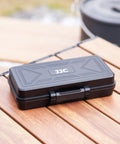 Black All In One Camera Battery And Memory Card Storage Case For Pro Gear on wooden table