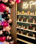 Hot Pink And Black Balloons Set 60 Count With Confetti, 12 Inch Latex Party Decorations arranged beside a party drinks display