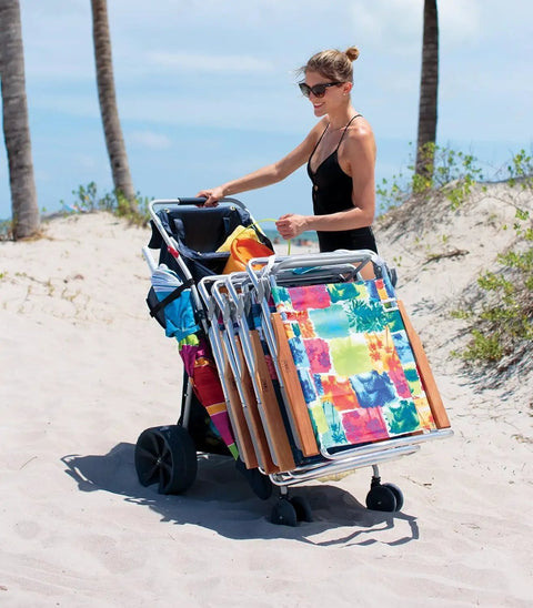 Woman using Wide Beach Cart Foldable Utility Cart With 48 Quart Cooler And Four Chairs, Easy 10 Inch Wheel Mobility on sand.