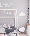 Floating Cloud Plug In Wall Sconce in matte white mounted in kids bedroom with gray walls and decor, 6ft clear cord visible.