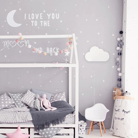 Floating Cloud Plug In Wall Sconce in matte white mounted in kids bedroom with gray walls and decor, 6ft clear cord visible.