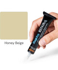 Hand holding Honey Beige Ceramic Tile Repair Kit with nanotech filler for cracked bathroom tiles.