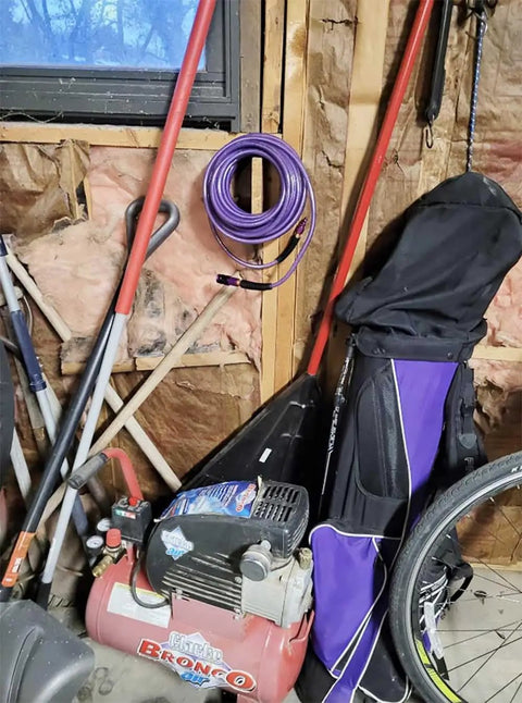 One Quarter Inch Polyurethane Air Hose Reinforced Lightweight Compressor Tubing Finish Safe And Slick Built Tough With Zero Drag For Auto Repair And Real Shop Grind Daily coiled above an air compressor in a garage.