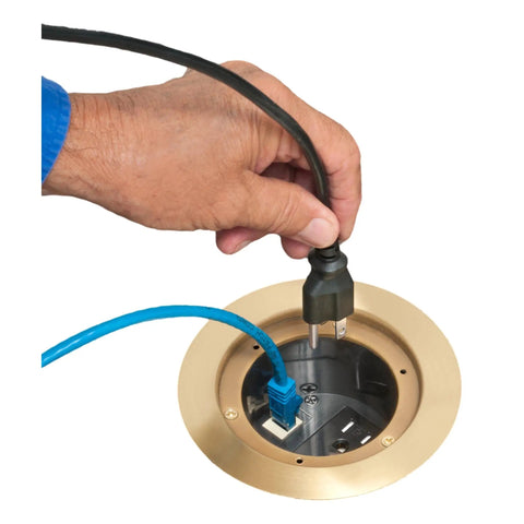 Hand plugging cables into Recessed Power And Data Round Floor Box For Concrete Floors With Brass Finish Fits Most 4.5 Inch Inside Diameter PVC Round Boxes 15 Amp Decora Style Outlet Opening And Low Voltage Keystone Data HDMI Phone Cable