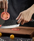 Hand Forged Meat Cleaver With Leather Sheath For Everyday Kitchen Prep slicing tomato on wooden board