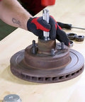 OEMTOOLS 27119 bearing race and seal driver set; gloved hand uses a steel driver on a rusted hub