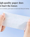 Glasses cleaning wipe, white, pre-moistened, held between fingers