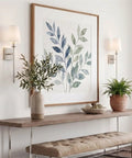 Kira Home Torche 20" Mid Century Modern Wall Sconce for Bathroom Vanity, Pack of 2, displayed beside a botanical artwork.