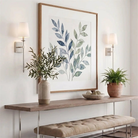 Kira Home Torche 20" Mid Century Modern Wall Sconce for Bathroom Vanity, Pack of 2, displayed beside a botanical artwork.