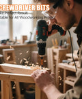 Person using a power drill with screwdriver bit for woodworking project in a workshop.
