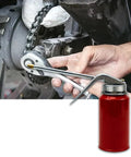 Metal hand-pump oil can with long chrome nozzle and brass tip used to oil a motorcycle chain.