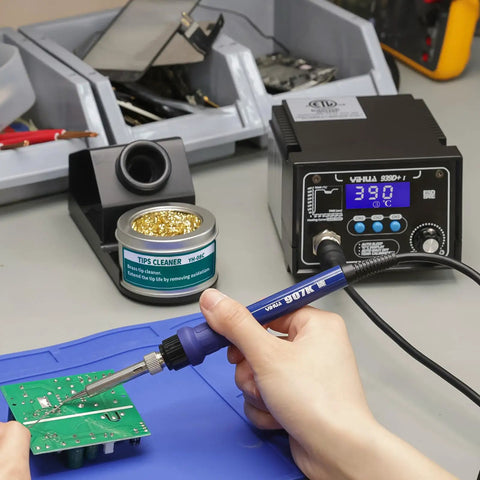 Person using Upgraded 939D I Soldering Station Pro Grade 75W Equivalent with 3 Memory Presets on a circuit board, LCD display shown.