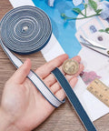 Dope Silk Ito Sageo Wrapping Cord 9.8 Ft Blue And White 0.4 Inch Wide for Sword Handle shown in hand with coin for scale