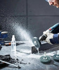Person using drill with 3-Piece Mounted Stone Grinding Wheel Set with 1/4 Inch Shank for metal grinding on workbench.