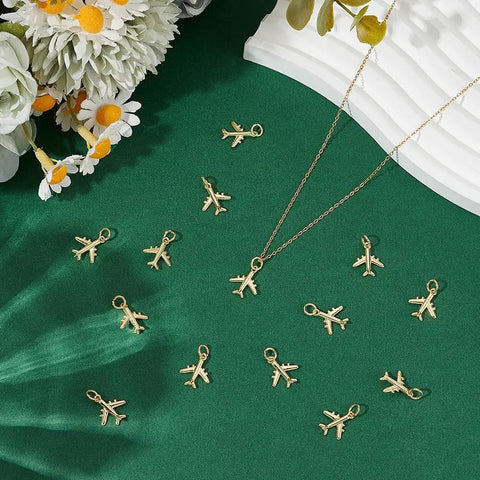 14 Pack Airplane Charms 18K Gold Plated Brass Plane Pendants With Jump Rings Bulk Jewelry Making Findings For Necklace Bracelet Keychain And Earring Projects DIY Craft Supplies Kit shown on green fabric