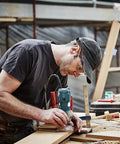 MNA 4‑Piece 45‑degree chamfer router bit set, 1/4" shank, in use by woodworker with handheld router
