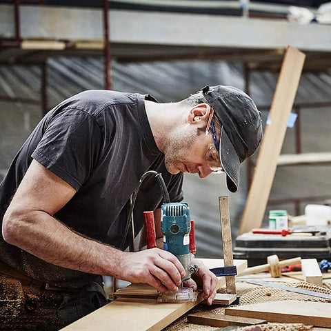 MNA 4‑Piece 45‑degree chamfer router bit set, 1/4" shank, in use by woodworker with handheld router