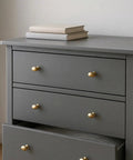 10 Pack Oval Champagne Bronze Cabinet Knobs And Furniture Pulls Single Hole Hardware Handle For Kitchen Cabinets Cupboards Dressers And Wardrobes Great For Modern Homes And Rustic Styles Easy Install Durable Finish shown on a grey dresser.