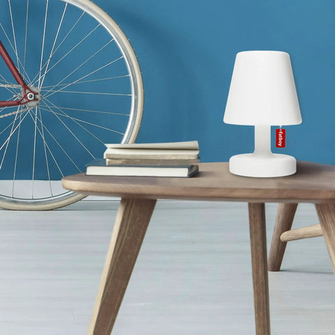 White Tiny Rechargeable LED Lamp 2.0 Go Anywhere Dimmable Table Light for Indoor and Outdoor Use, on wooden table