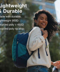 Daylite Expandable 26 Plus 6 Travel Pack Black Lightweight Durable Daypack With 6L Expansion worn by a smiling woman outdoors