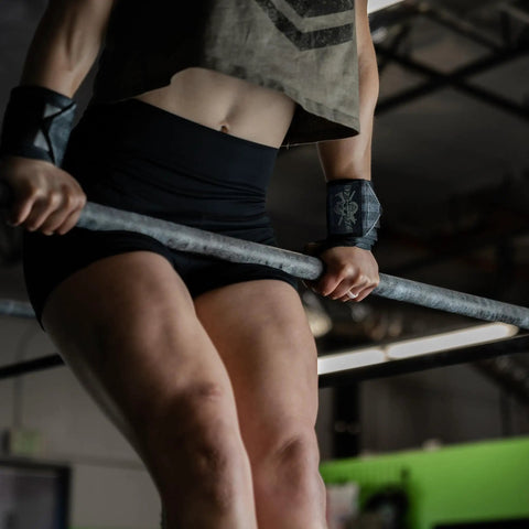Person using 18 Inch Heavy Duty Wrist Wraps For Weightlifting And Powerlifting With Ultra Strong Support For Bench Press, Deadlifts, Curls, CrossFit, And General Gym Workouts For Men while lifting a barbell.