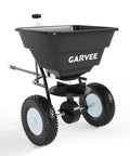 Tow Behind Broadcast Spreader With 110 Lb Hopper Universal Hitch Hopper Cover And Adjustable Flow Control For Seed Fertilizer Salt And Ice Melt Perfect For Big Lawn Jobs Black in side view with large wheels and black hopper.
