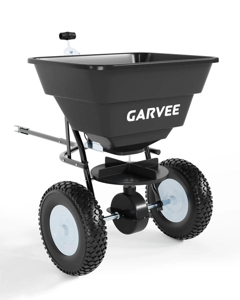 Tow Behind Broadcast Spreader With 110 Lb Hopper Universal Hitch Hopper Cover And Adjustable Flow Control For Seed Fertilizer Salt And Ice Melt Perfect For Big Lawn Jobs Black in side view with large wheels and black hopper.
