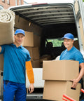 Two men wearing blue shirts and caps carry items in a van, one with Pro Level Heavy Duty Cowhide Leather Arm Sleeves Heat Resistant.
