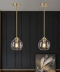 MQMQA 2 Pack Globe Pendant Lights, Mid Century Brass Pendant Light Fixtures with clear glass shades in modern interior.