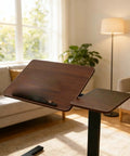 Solid Mobile Standing Desk With Pneumatic Lift And Tilt Top, Smooth Swivel Casters, Heavy Duty Steel Frame Walnut Laptop Workstation For Home Office Flex Bedside Chill side view in a cozy setting.