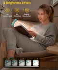 Glocusent USB rechargeable clip-on book light in teal clipped to a book for bedtime reading