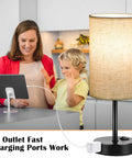 Set Of 2 Bedside Table Lamps For Bedroom And Living Room With 3 Way Dimmable Rocker Switch And Built In AC Outlet Flaxen Fabric Shade Black Base Nightstand And Desk Lamp For Cozy Home Decor shown charging a tablet on a kitchen counter.