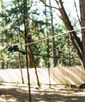 Backyard Zip Line Kit With Riding Gear, Heavy Duty 350 Pound Capacity, cable stretched between trees in wooded area