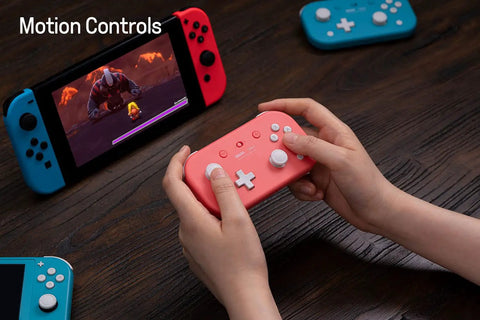 Hands holding Pocket Sized Lite 2 Bluetooth Controller With Motion Controls for Nintendo Switch On The Go, in pink color.