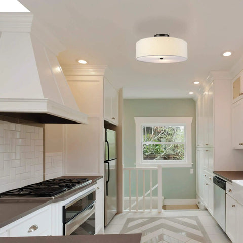 Two Light Flush Mount Ceiling Light In Dark Bronze With White Linen Drum Shade, Low Profile Design, shown in a kitchen setting