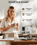 Compact Stainless Steel Espresso Machine with milk frother for home cafe drinks, user enjoying coffee at kitchen counter.