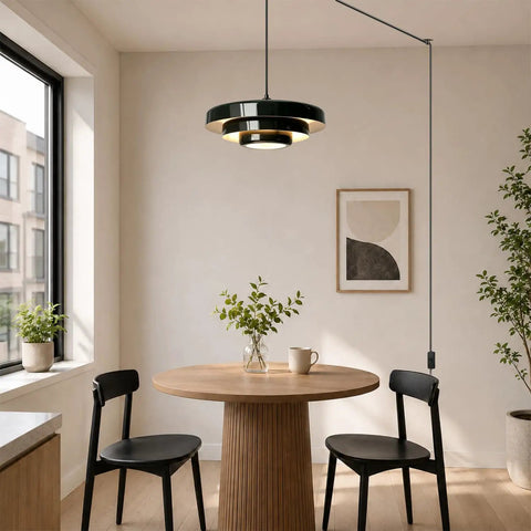 Black Swag Pendant Light Plug in hanging over a round dining table with layered metal shade and adjustable cord.