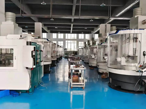 CNC milling machines in a spacious factory workshop with a blue floor.