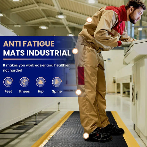Person standing on an Anti Fatigue Standing Mat For Workshops 3 By 5 Feet Beefed Up Industrial Grade Ergonomic Floor Mat Nearly One Inch Thick With Non Slip Surface And Yellow Border For Leg And Back Pain Relief On Long Shifts in an industrial setting.