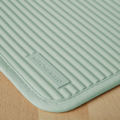 Close-up of ribbed soft silicone pot holder 2 pack set in pistachio green 7x9 inches heat resistant up to 500F waterproof slip resistant.
